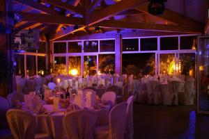 - une salle de banquet avec des tables blanches, des chaises et des lumières dans l'établissement Il Pelagone Hotel & Golf Resort Toscana, à Gavorrano 130 autres photos