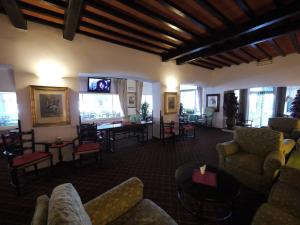 un soggiorno con divani, sedie e TV di Hotel Piccadilly a Lido di Camaiore