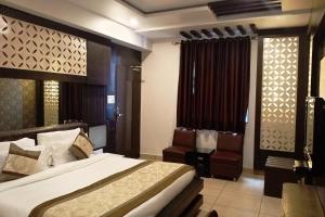 ラクナウにあるHotel Surya Internationalのベッドと椅子のあるホテルの部屋