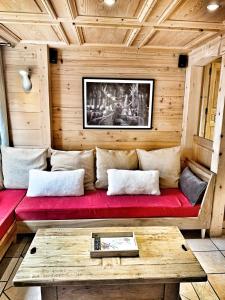 ノートル・ダム・ド・ベルコンブにあるChalet Marie Claireのリビングルーム(赤いソファ、テーブル付)