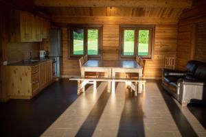 eine Küche und ein Esszimmer mit einem Tisch in einer Hütte in der Unterkunft Trejdekšņi in Limbaži