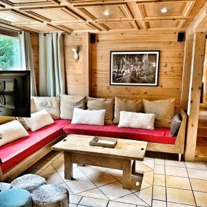 ノートル・ダム・ド・ベルコンブにあるChalet Marie Claireのリビングルーム(赤いソファ、テーブル付)