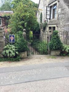 a gate in front of a house with a sign on it at Dove Cottage in Bisley