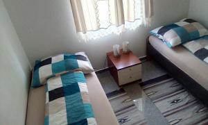 黑马戈尔Apartment Ereiz的一间小卧室,配有两张床和一张桌子