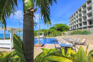 un complejo con una palmera y una piscina en PH El Palmar Residences 2203, en San Carlos