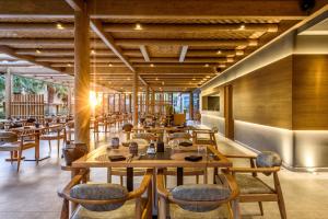a restaurant with wooden tables and chairs at Stella Palace Aqua Park Resort in Hersonissos
