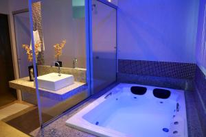 a bathroom with a tub with a sink and a shower at Monte Castro Executive Hotel in Araguari