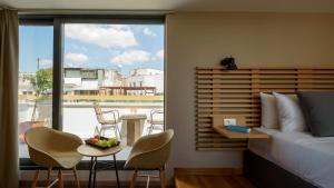 - une chambre avec un lit, une table, des chaises et une fenêtre dans l'établissement Fos DownTown Suites, à Athènes