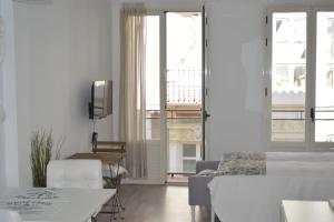 a living room with a bed and a table and chairs at Modern studio flat close to Plaza Merced in Málaga