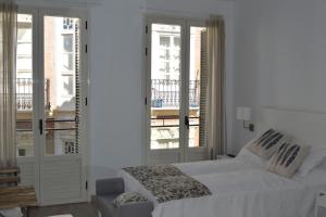 Biała sypialnia z łóżkiem i balkonem w obiekcie Modern studio flat close to Plaza Merced w Maladze