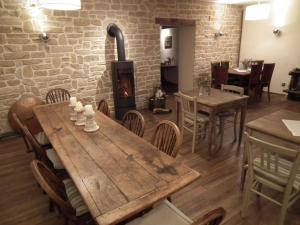 a dining room with a wooden table and a fireplace at Hotel Café del Maar in Schalkenmehren