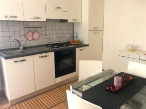 a kitchen with white cabinets and a table and a sink at Casa al Castello in Isola del Giglio