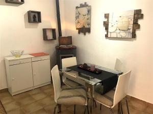 ein Esszimmer mit einem Tisch und weißen Stühlen in der Unterkunft Casa al Castello in Isola del Giglio