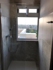 a bathroom with a shower with a window at Villa Chossie in Żejtun