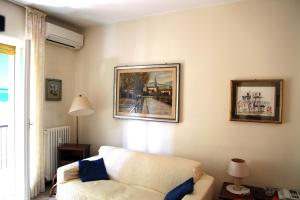 ein Wohnzimmer mit einem weißen Sofa und Bildern an der Wand in der Unterkunft Delizia apartment in Rapallo