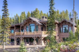 a log home with a wrap around deck in the woods at Hoos Views in Big Sky Mountain Village