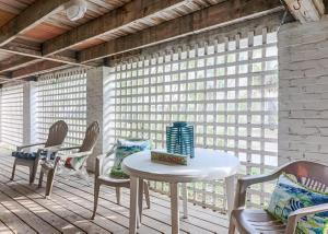 a white table and chairs on a porch with windows at 19th St. Beachside Hideaway in Tybee Island