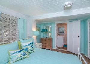um quarto azul com uma cama e uma porta para um corredor em 19th St. Beachside Hideaway em Tybee Island