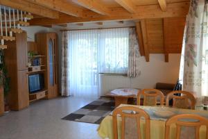 sala de estar con mesa, sillas y TV en Ferienwohnung beim Pauli, en Titisee-Neustadt