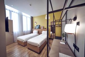 a hotel room with two beds and a lamp at Maison Nô - Hôtel et Rooftop in Lyon +37 photos