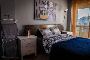 sypialnia z łóżkiem z niebieską kołdrą w obiekcie Timax Home Costa del Sol w mieście Caleta De Velez