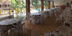 a row of tables and chairs in a restaurant at Pousada Aldeia das Flores in Olímpia