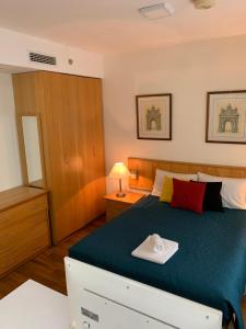 a bedroom with a bed with a green comforter at Charmoso Flat em Pinheiros in Sao Paulo +71 photos