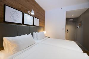 ジェネラル・サントスにあるAvior Hotelの白い枕が付いた大きなベッドのある寝室