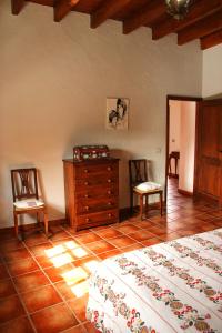 1 dormitorio con 2 camas, vestidor y 2 sillas en Casa Rural los Ajaches, en Yaiza