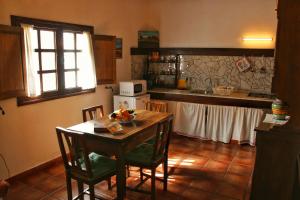 cocina con mesa con sillas y microondas en Casa Rural los Ajaches, en Yaiza