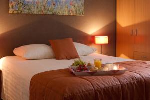 a tray of fruit on a bed in a hotel room at Appartementen Valkenburg in Valkenburg