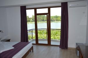 Schlafzimmer mit Balkon und Blick auf das Wasser in der Unterkunft Hotel Insula in Neptun