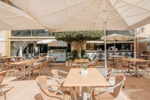 an empty restaurant with tables and chairs and umbrellas at Hotel Cleopatra Palace in Playa de las Americas