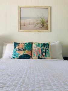 um quarto com uma cama com almofadas e um espelho em The Ocean Resort Inn em Montauk