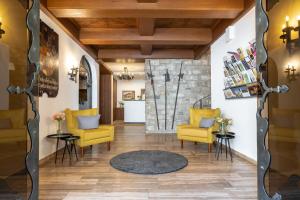 a hallway with yellow chairs and a stone wall at Hotel & Restaurant Ritter Jörg in Sommerhausen