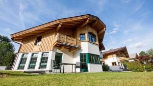 dom z drewnianym dachem na górze w obiekcie Leni´s Appartements w mieście Fieberbrunn
