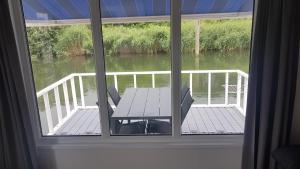 einen Blick aus dem Fenster einer Terrasse mit einem Tisch und Stühlen in der Unterkunft BestMarine Waterchalets Flevo Marina in Lelystad