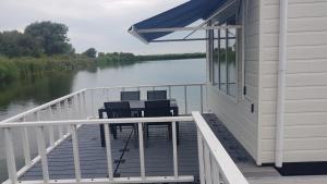 a deck with four chairs on the side of a house at BestMarine Waterchalets Flevo Marina in Lelystad