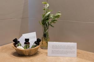 a basket of wine bottles on a table with a vase at Torre Bonera. Green Resort in Menfi