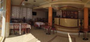 a restaurant with tables and chairs and a bar at Hotel Chicago in Sarandë