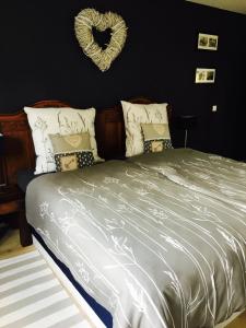 ein Schlafzimmer mit einem Bett mit einem Herzkranz an der Wand in der Unterkunft Gästehaus Sellemols Ferienwohnung Korbmacher in Heuchelheim-Klingen