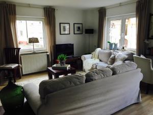 uma sala de estar com um sofá e uma televisão em Gästehaus Sellemols Ferienwohnung Korbmacher em Heuchelheim-Klingen