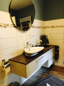 a bathroom with a sink and a mirror at Gästehaus Sellemols Ferienwohnung Korbmacher in Heuchelheim-Klingen +17 photos