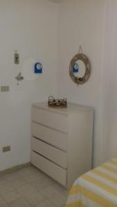 パリヌーロにあるI Faraglioniのベッドルーム1室(ドレッサー、壁掛け時計付)
