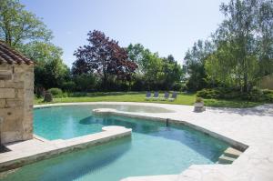 een zwembad met blauw water in een tuin bij Logis Saint Léonard in Dompierre-sur-Mer