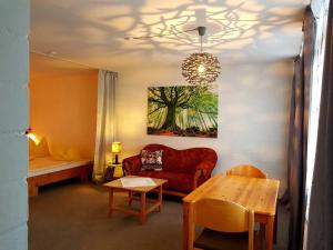 a living room with a red couch and a table at Berg-Bungalows Leinleitertal in Heiligenstadt