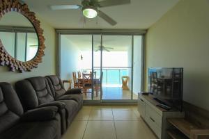 - un salon avec un canapé et une télévision dans l'établissement 2201 Playa EL Palmar, à Las Palmeras