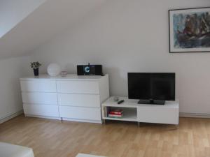 sala de estar con TV y tocador blanco en Ferienwohnung Bummelallee en Bad Harzburg