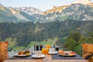 uma mesa com comida e bebidas e vista para as montanhas em Hotel Waldegg - Adults only em Engelberg