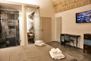 a bathroom with a shower and towels on the floor at Palazzo Murat B&B in Monopoli